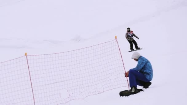Soczi, Rosja - 4 kwiecień 2016: Snowboardzista jazdy na stoku skakać z trampoliny wysoki na ośrodek narciarski. Active sport — Wideo stockowe