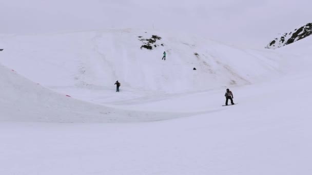 Sochi, Rusko - duben 4, 2016: Snowboardista skákat z vysokých odrazový můstek na lyžařské středisko, chytit ve vzduchu. Krajina — Stock video