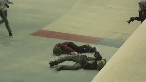 Krasnojarsk, Rusko - 15. březen 2014: Lidé přicházejí se chlapci lež na podlaze po těžké srážce v skate parku. Bruslaři. Poranění hlavy — Stock video