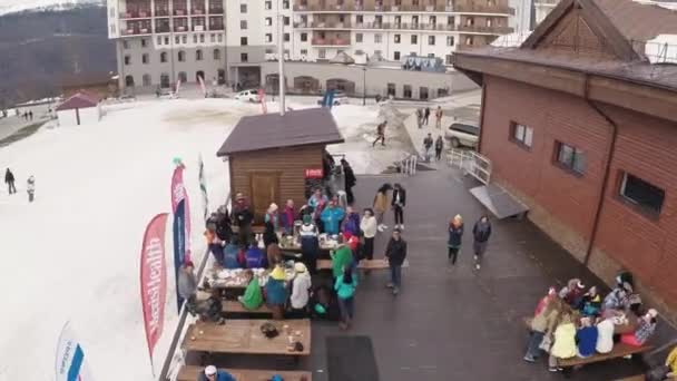 索契，俄罗斯-2016 年 4 月 1 日︰ 直升机飞过人们放松，吃在山上的咖啡吧。滑雪胜地。雪 — 图库视频影像