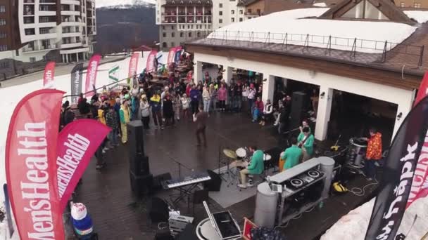 SOCHI, RUSIA - 1 DE ABRIL DE 2016: Quadrocopter shoot music band perform at mountain. Estación de esquí. Gente animando — Vídeos de Stock