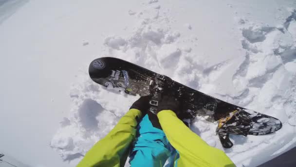 СОЧИ, РОССИЯ - 1 апреля 2016 года: Сноубордист чинит сапоги на сноуборде на вершине снежной горы. Экстремальный спорт — стоковое видео