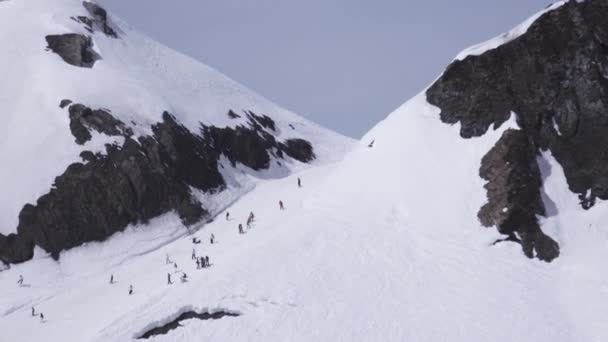 Sochi, Ryssland - April 1, 2016: Ski resort. Landskap med snötäckta berg. Snowboardåkare och skidåkare ridning. Soligt — Stockvideo