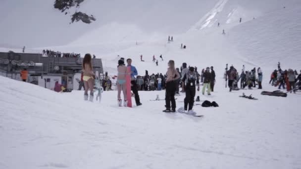 Sotschi, Russland - 1. April 2016: Skigebiet. Snowboarderinnen im Bikini. Menschen im Lager. Skifahrer. Berge — Stockvideo