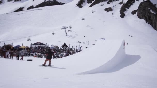 SOCHI, RUSSIA - APRIL 1, 2016: Ski resort. Snowboarder high jump from springboard. Turning in air. People. — Stock Video