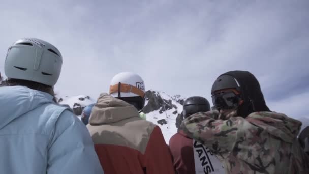 Sotschi, Russland - 1. April 2016: Die Rückseite der Snowboarder und Skifahrer bleibt oben auf der Piste. Helm. Extremsport — Stockvideo