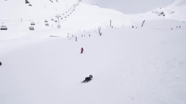 SOCHI, RUSIA - 1 DE ABRIL DE 2016: Estación de esquí. Esquiador deslizándose por el sendero. Gente. Montañas nevadas. Trucos extremos. Traje — Vídeos de Stock