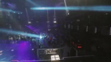 Soçi, Rusya - 8 Nisan 2016: İnsanlar parti gece kulübünde tezahürat kalabalık. Mavi lazer gösterisi kirişler. DJ dans