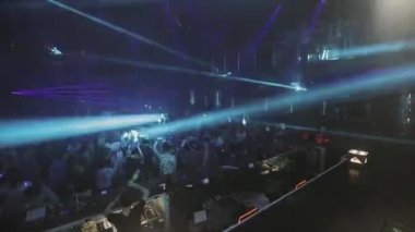 Sochi, Rusya - 8 Nisan 2016: İnsanlar dans partisi gece kulübünde, kalabalık. Mavi lazer gösterisi kirişler. Aydınlatma