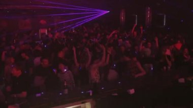 Soçi, Rusya - 8 Nisan 2016: İnsanlar parti gece kulübünde tezahürat kalabalık. Mor lazer gösterisi kirişler. Bar