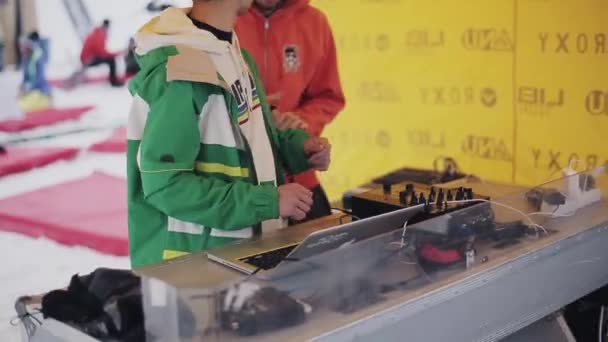 俄罗斯索契-2016 年 4 月 6 日︰ Dj 太阳镜在滑雪场上一方的黄色帐篷里搅拌。微笑。笔记本电脑. — 图库视频影像