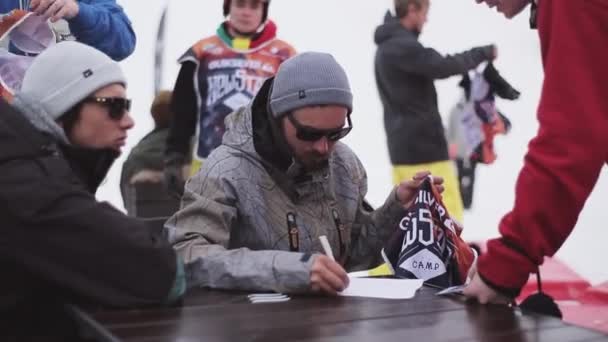 Sochi, Ryssland - April 6, 2016: Man skriva lista över deltagare i tävlingen på skidorten. Ge skjortor med nummer — Stockvideo