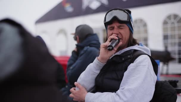 Sochi, Ryssland - April 6, 2016: Mannen med mikrofon säga bland snowboardåkare och skidåkare på skidorten. Idrott — Stockvideo