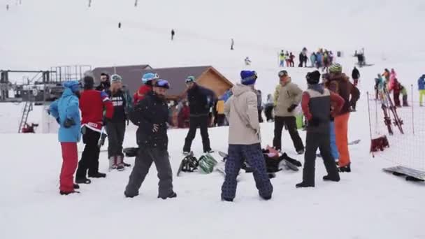 СОЧИ, РОССИЯ - 6 апреля 2016 года: группа сноубордистов разогревается перед поездкой на лыжном курорте. Делай упражнения. Снег — стоковое видео