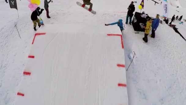 SOCHI, RUSIA - 7 DE ABRIL DE 2016: Quadrocopter disparar snowboarder saltar sobre trampolín. Estación de esquí. Gente montando — Vídeos de Stock