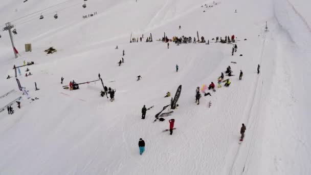 SOCHI, RUSSIA - APRIL 7, 2016: Quadrocopter shoot snowboarder jump over springboard and falling. Ski resort — Stock Video