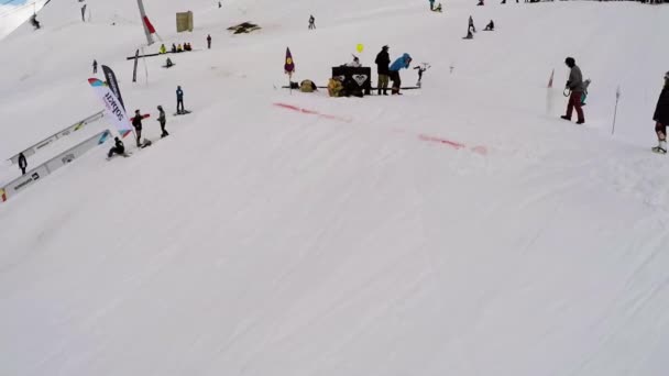 Sochi, Російська Федерація - 7 квітня 2016: Quadrocopter стріляти сноубордистів стрибок над трампліном і стежок. Гірськолижний курорт — стокове відео