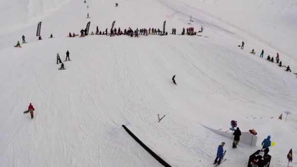 SOCHI, RUSIA - 7 DE ABRIL DE 2016: Quadrocopter disparar snowboarder estancia en el trampolín. Estación de esquí. Concurso. Buenas noches. — Vídeos de Stock