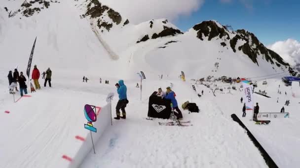Sochi, Rusko - 7. dubna 2016: Quadrocopter natáčení snowboardista skok přes můstek, aby převrátí. Zasněžené hory — Stock video