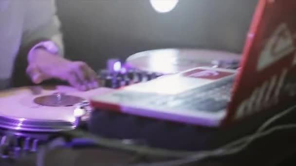 Sotschi, Russland - 8. April 2016: DJ dreht am Plattenteller auf Party im Nachtclub. Laptop. Scheinwerfer. Tätowierung. — Stockvideo