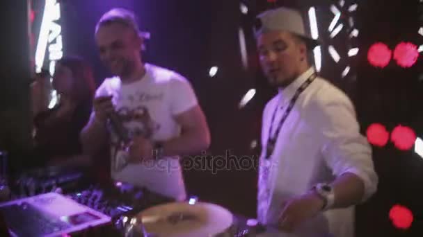 SOCHI, RUSSIA - APRIL 8, 2016: Dj spinning at turntable on party in nightclub. Spotlights. Mc girl and boy. — Stock Video