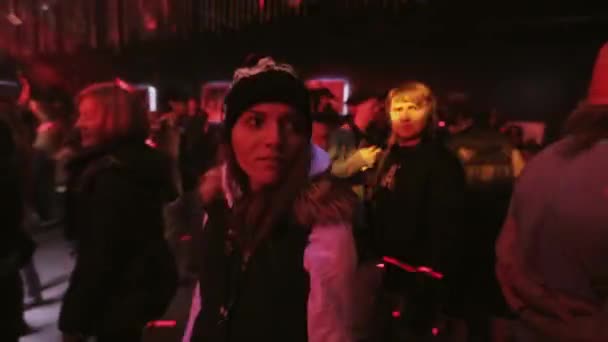 Sochi, Rusland - 8 April 2016: Meisje met hoed wandeling op party in discotheek. Mensen dansen. Schijnwerpers. Laser-show. — Stockvideo