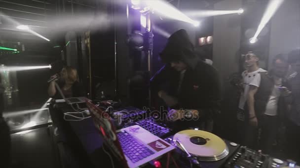 Soczi, Rosja - 8 kwietnia 2016: Dj rotująca gramofon na party w klubie nocnym. Ludzie tańczą. Białe reflektory — Wideo stockowe