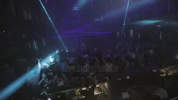 Sochi, Rusko - 8. dubna 2016: Houf lidí, kteří tančí na párty v nočním klubu. Modré a fialové laserové show nosníky. — Stock video