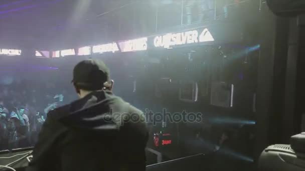 Sotschi, Russland - 8. April 2016: Rückseite eines DJs, der sich am Plattenteller auf einer Party im überfüllten Nachtclub dreht. Scheinwerfer. — Stockvideo
