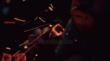 Genç adam nargile gecede canlı kömür üfle. Sparks. Yangın. Rüzgar. Yasaktır