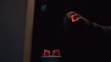 Genç adam nargile gecede canlı kömür üfle. Sparks. Bağımlılığı. Yasaktır