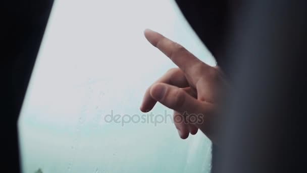 Man touching window in car by one finger. Rainy weather outside. Drops — Stock Video