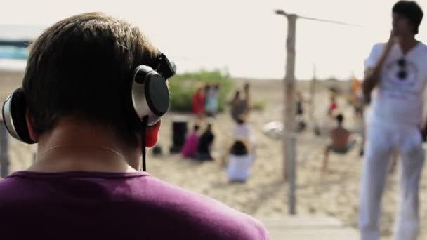 SAINT PETERSBURG, RÚSSIA - JUNHO 6, 2016: Dj em fones de ouvido na plataforma giratória na praia. Aperto de mão com o homem. Verão dia ensolarado . — Vídeo de Stock