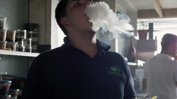 SAINT PETERSBURG, RUSSIE - 18 AOÛT 2016 : Le jeune homme respire la vapeur de la cigarette électronique au bar du restaurant . — Video