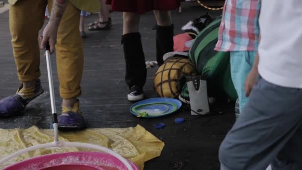 Sint-Petersburg, Rusland - 18 augustus 2016: Bereiden Animator in kostuum make grote zeepbellen op terras. Entertainment. — Stockvideo