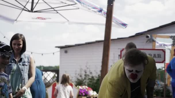 Sint-Petersburg, Rusland - 18 augustus 2016: Animator in clown kostuum make grote zeepbel op terras van het restaurant. Leuk — Stockvideo