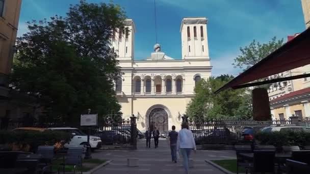 SAINT PETERSBURG, RÚSSIA - 19 de julho de 2016: Igreja Luterana de São Pedro e São Paulo em São Petersburgo. As pessoas andam — Vídeo de Stock