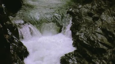 Su akışı deliğe kayaların üzerinden akar. Sıçrama. Yaz günü. Manzara. Doğa. Taşlar
