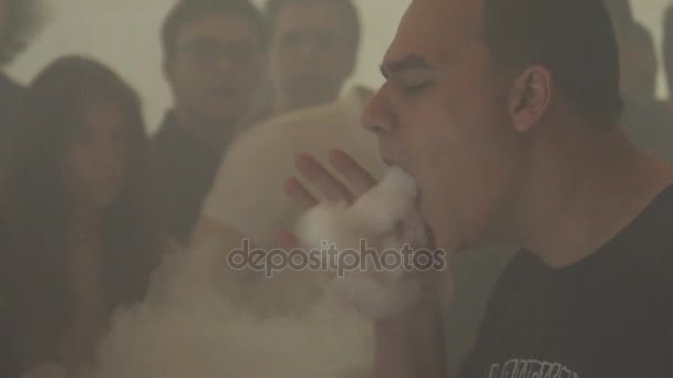 俄罗斯圣彼得堡-2016 年 5 月 28 日︰ 男子呼气云的蒸汽从电子香烟。云顶。吸烟者。人. — 图库视频影像