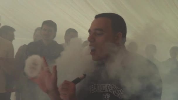 俄罗斯圣彼得堡-2016 年 5 月 28 日︰ 人呼气形成的蒸汽从电子香烟。云顶。吸烟者。人. — 图库视频影像
