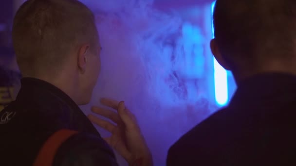 SAINT PETERSBURG, RUSIA - 28 mai 2016: Bărbatul fumează țigări electronice în clubul de noapte. Festivalul Vapers Steam . — Videoclip de stoc