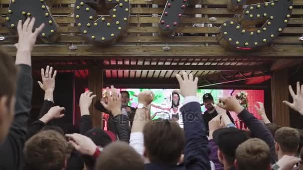 SAN PETERSBURG, RUSIA - 28 DE MAYO DE 2016: La gente levanta la mano. Anfitrión con micrófono lanza frascos en multitud desde el escenario. Vaper. — Vídeos de Stock