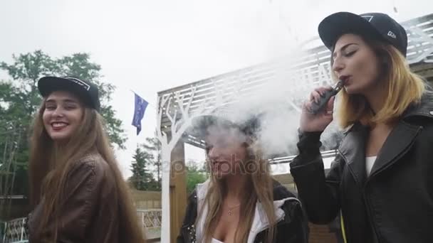 SAINT PETERSBURG, RUSSIE - 28 MAI 2016 : Les filles aux lèvres rouges fument des cigarettes électroniques dans la rue. Vaper. Pose sur la caméra — Video