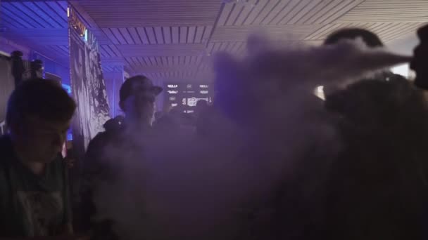 Sankt Petersburg, Ryssland - 28 maj, 2016: Män röka elektroniska cigaretter i nattklubb vid bord. Vejpare. Strålkastare — Stockvideo