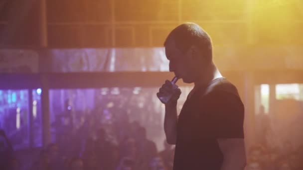 SAINT PETERSBURG, RUSIA - 28 DE MAYO DE 2016: El hombre exhala vapor del cigarrillo electrónico en la discoteca. Fiesta. Foco. Vaper. — Vídeo de stock