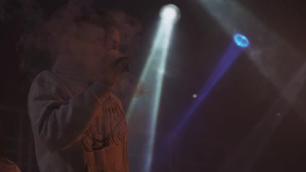 SAINT PETERSBURG, RUSSIA - 28 MAGGIO 2016: Ragazzo fuma sigaretta elettronica sul palco del nightclub. Vapore. Proiettori . — Video Stock