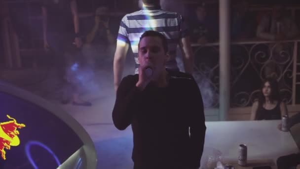 Saint petersburg, russland - 28. Mai 2016: Zwei Jungen atmen in einem Nachtclub Dampf aus einer elektronischen Zigarette aus. Herausforderung. Bühne — Stockvideo