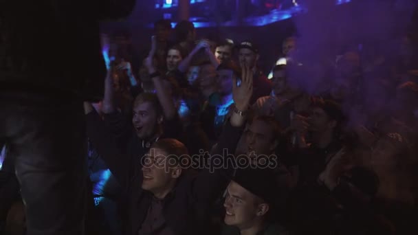 SAN PETERSBURG, RUSIA - 28 DE MAYO DE 2016: Los jóvenes levantan la mano, aplauden en el club nocturno. Vapor del cigarrillo electrónico — Vídeos de Stock