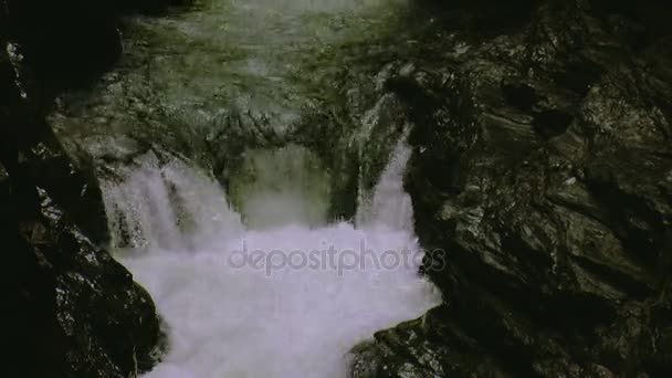 Er stroomt water van stroom uit de rotsen in gat. Splash. Zomerdag. Landschap. Natuur. Spray. Stenen — Stockvideo