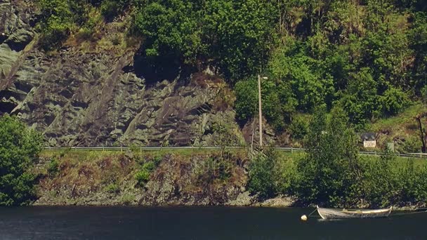Panoramautsikt tom träbåt våg på vattnet i floden i berg. Gröna träd. Solig sommardag — Stockvideo
